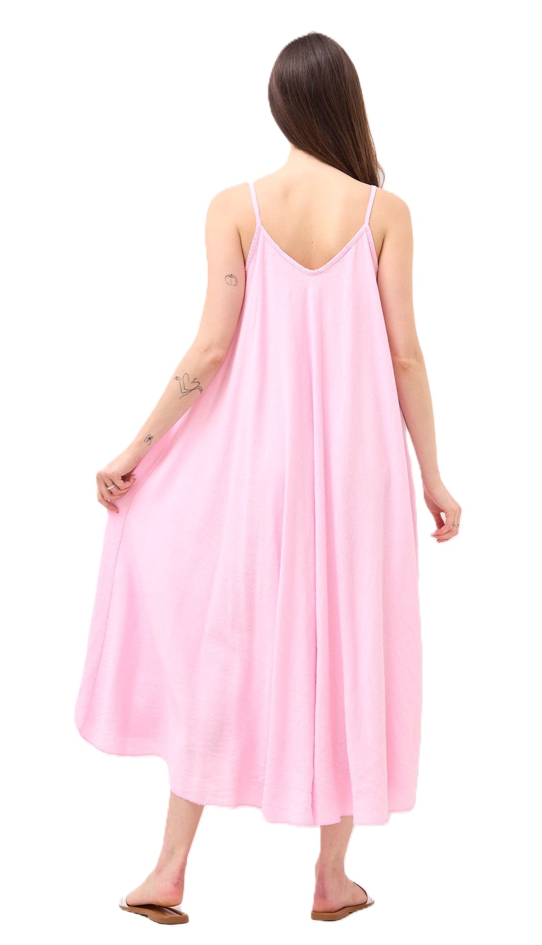 Woman wearing a pink slip maxi dress on a white background