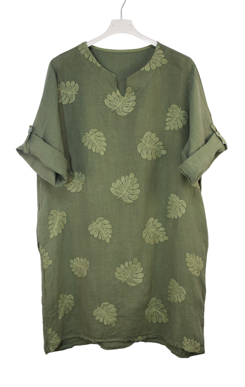 Green dress with embroidered leaf patterns on a white background