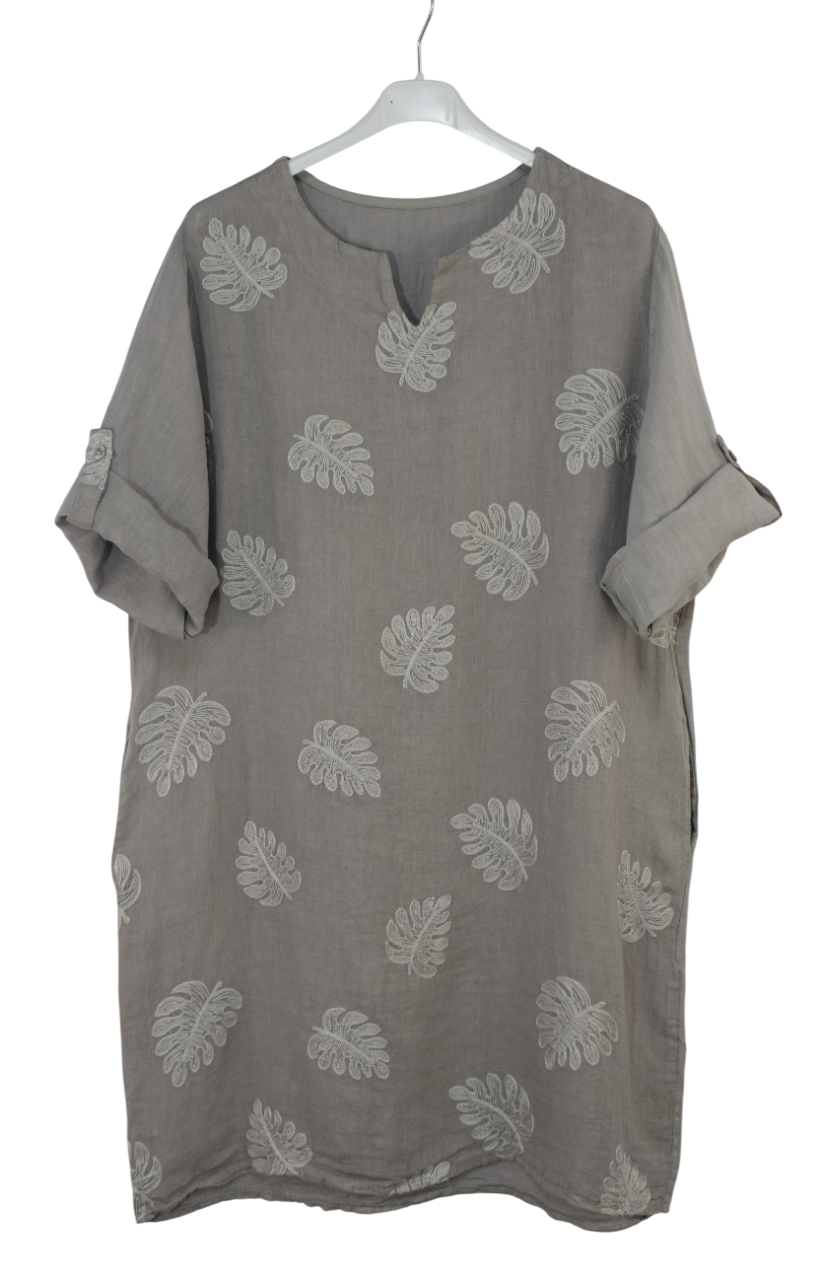 Mocha coloured dress with embroidered leaf patterns on a white hanger
