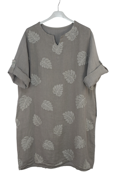 Mocha coloured dress with embroidered leaf patterns on a white hanger